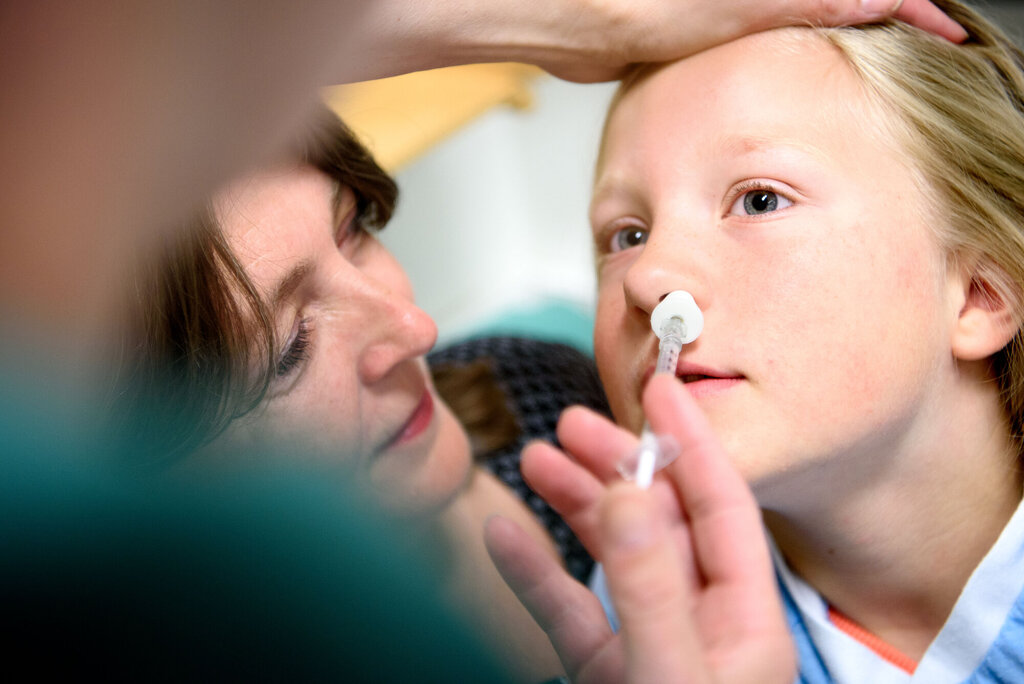 Bildet viser ei jente som får deksmedetomidin i form av nesespray før operasjon