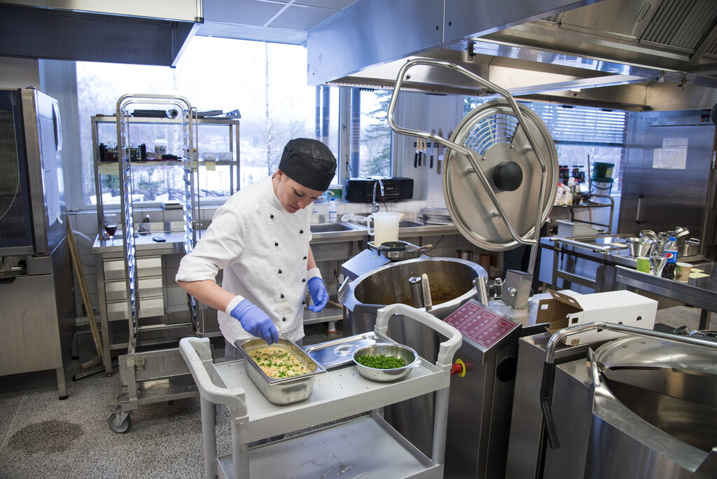 Bildet viser Kine Haugen som tilbereder middag på Døli pleie- og omsorgssenter i Nittedal.