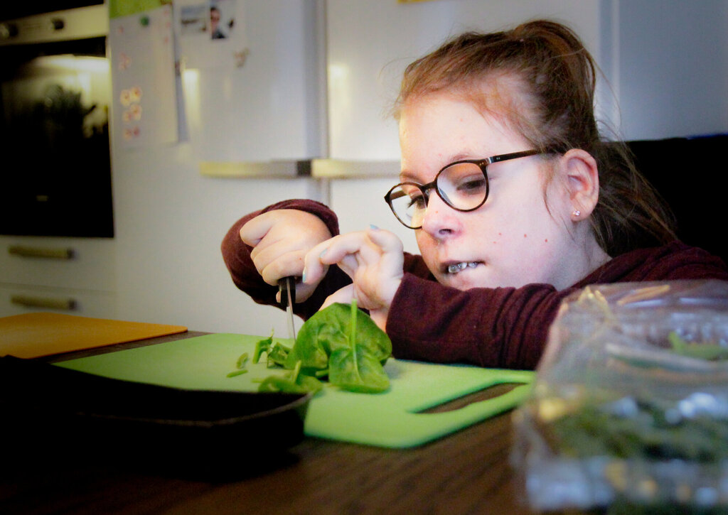 Bildet viser at Emma skjærer salat