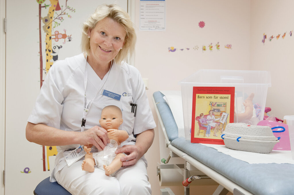 Bildet viser Astrid Ingeborg Austrheim som holder en dukke med pose på magen.