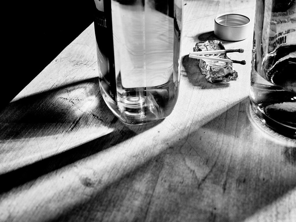 Spritflaske og brente fyrstikker på et bord