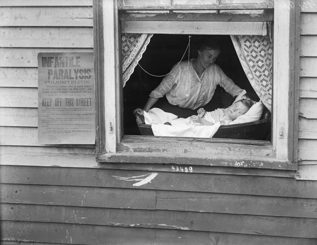 Bildet viser kvinne og barn i et vindu under polioepidemien i USA i 1916.