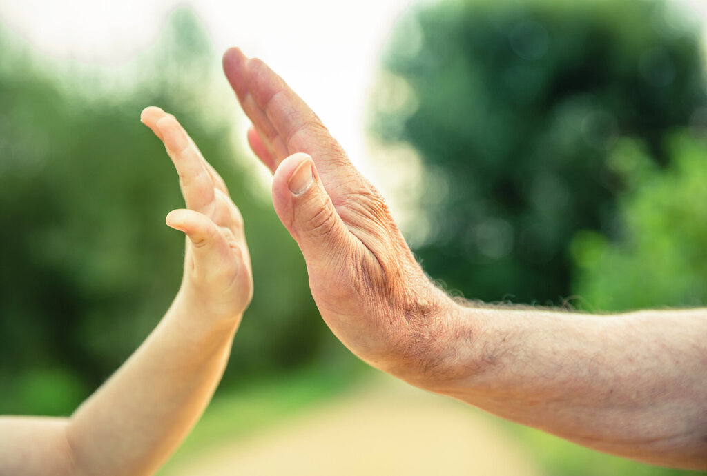 Bildet viser en voksen- og en barnehånd som slår "high five"