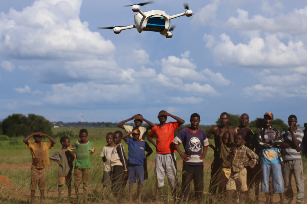 Bildet viser en menneskemengde som ser på en drone som flyr over dem.