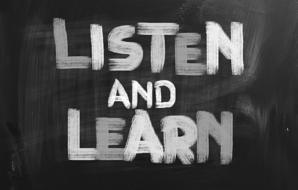 Tavle med teksten "Listen and learn"