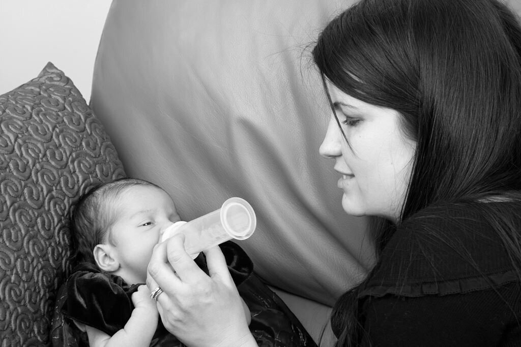 Kvinne gir baby melk av flaske