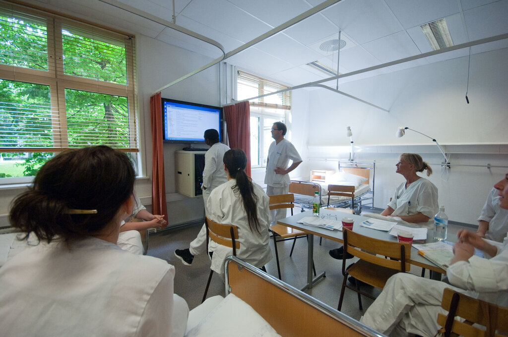Bildet viser sykepleierstudenter ved Høgskolen i Oslo og Akershus inne i et undervisningsrom. Alle har uniformer på.