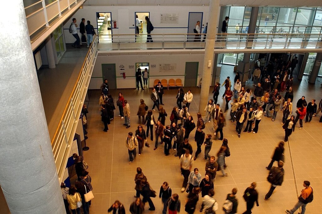 Viser studenter som går rundt i aulaen på en høgskole/univeresitet