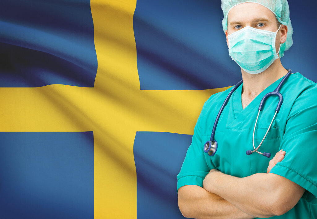 Svensk sykepleier med flagg i bakgrunnen