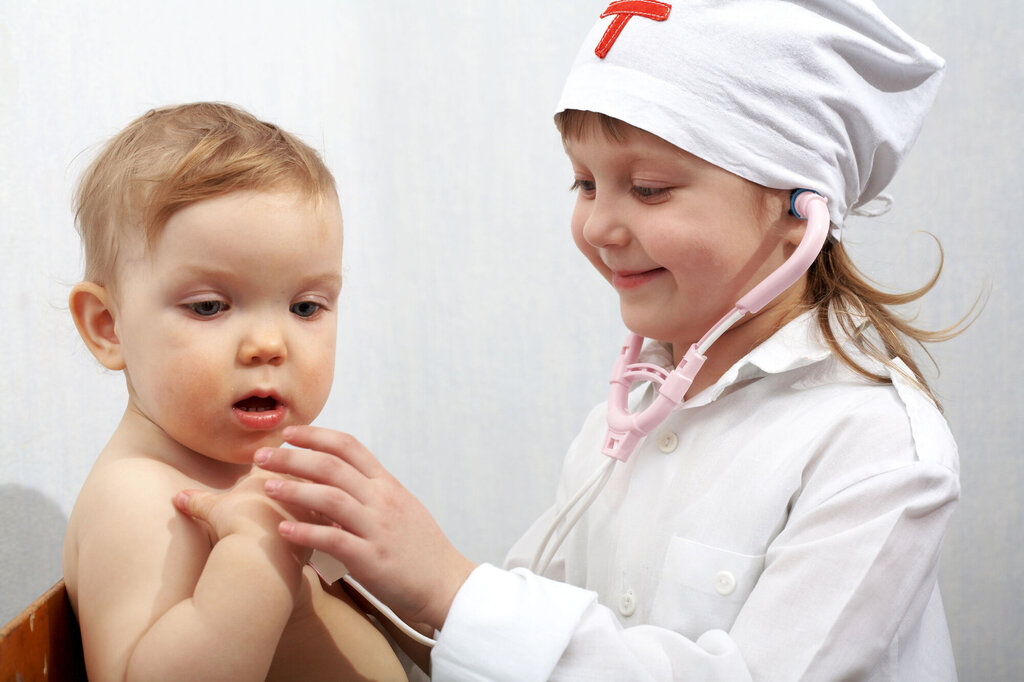 To små barn som leker sykepleier og pasient