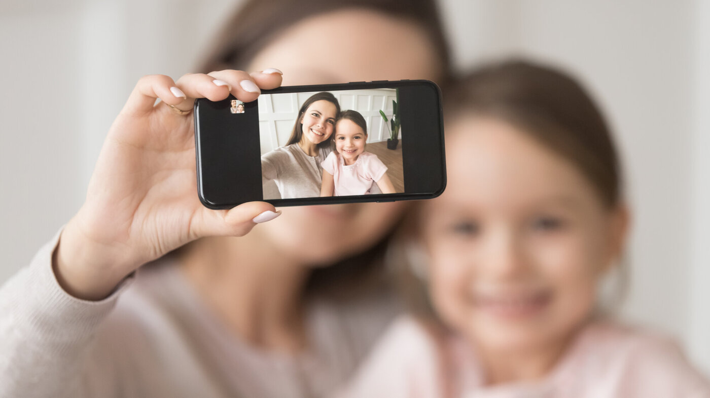Bildet viser en mor som tar selfie av seg selv og datteren.