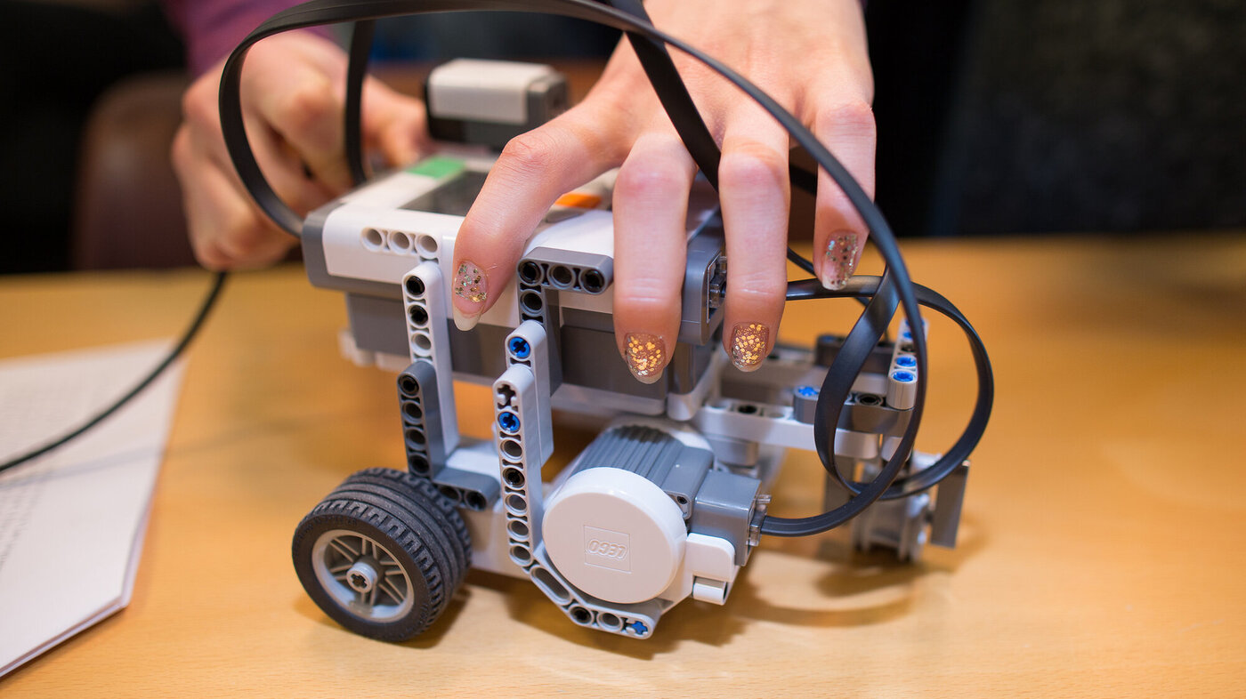 Bildet viser jentefingre som bygger en legorobot ved NTNU