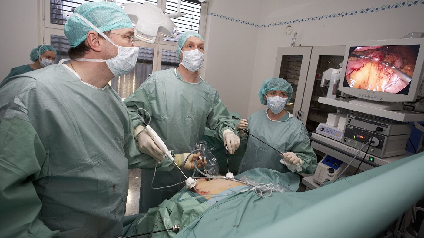 Kirurger utfører hysteroskopi, og følger med på en skjerm.