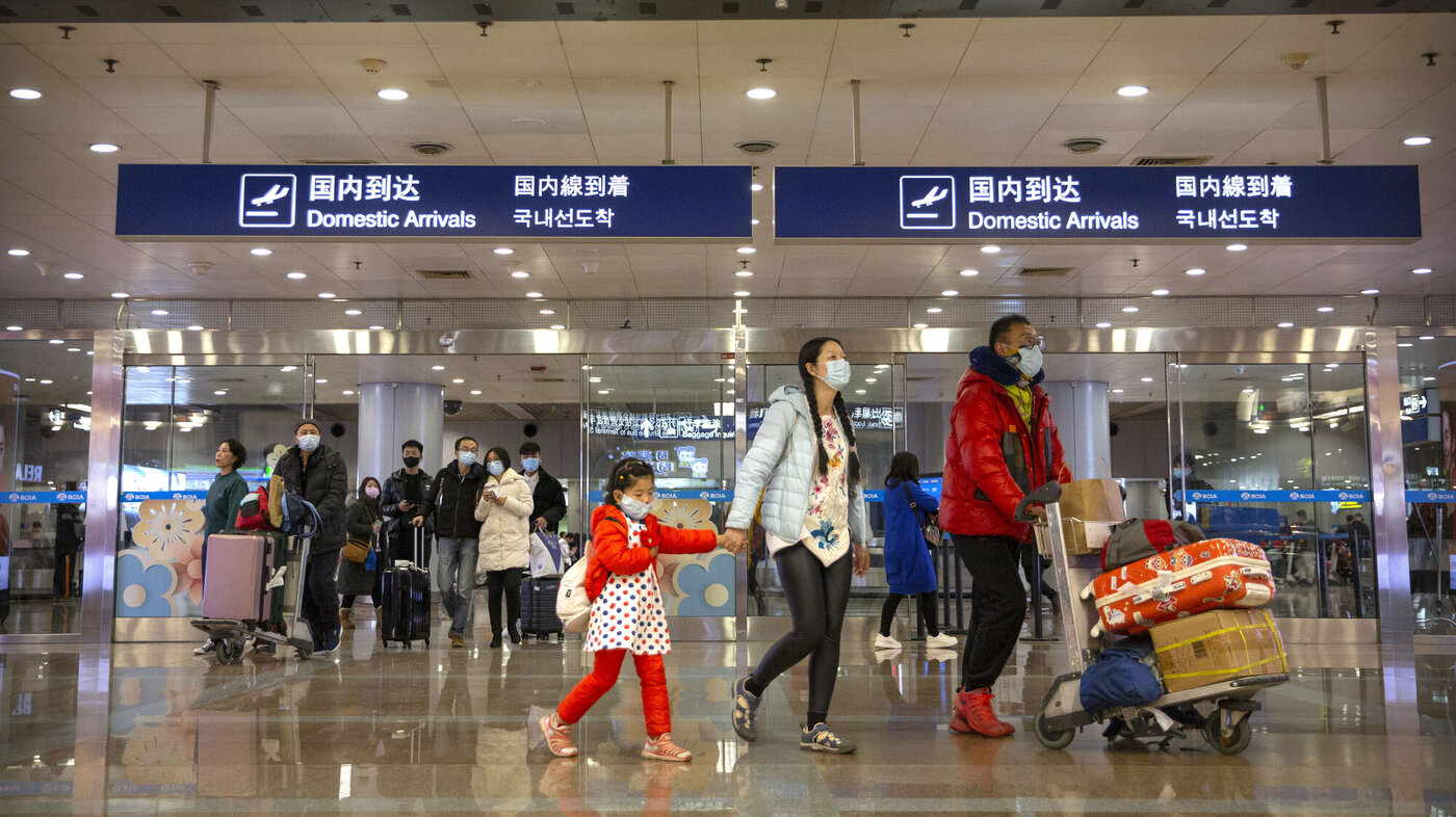 Passasjerer med fly fra Wuhan har ankommet Beijing internasjonale flyplass 23. januar. Passasjerene bruker munnbind.