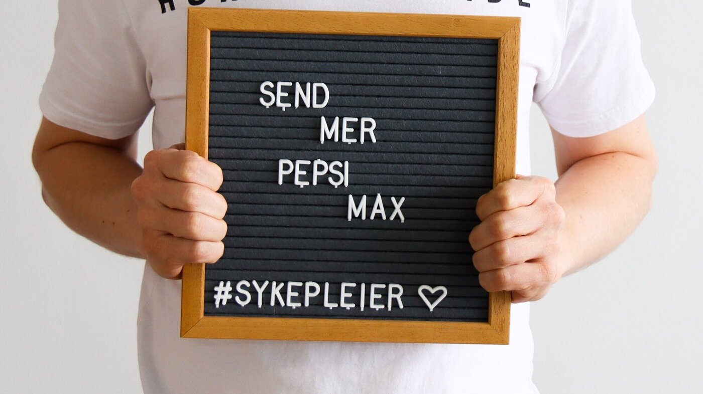 Bildet viser Anders Christoffersen som holder opp en tavle der det står send mer pepsi max.