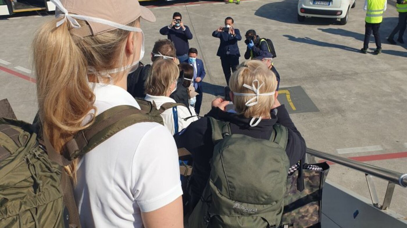 Bildet viser medisinsk innsatsteam på vei ut av flyet i Bergamo.