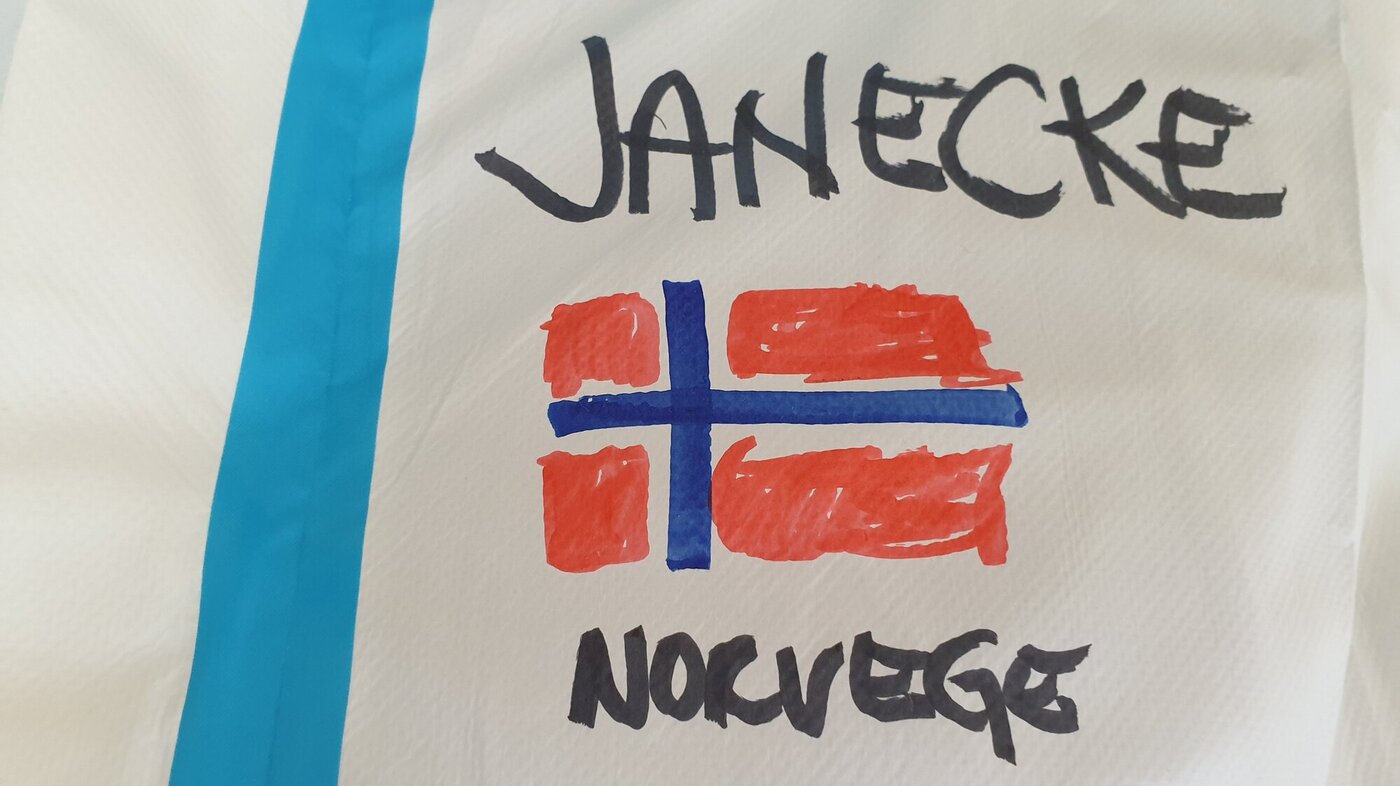 Bildet viser en smitteverndrakt med et tegnet norsk flagg på og navnet Janecke.