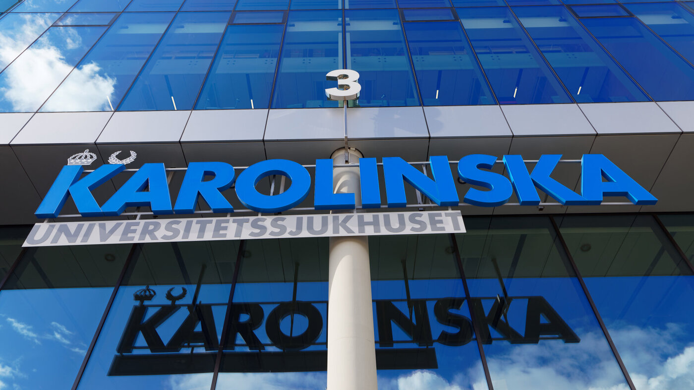 Bildet viser en bygning med et skilt der det står Karolinska i blå bokstaver.