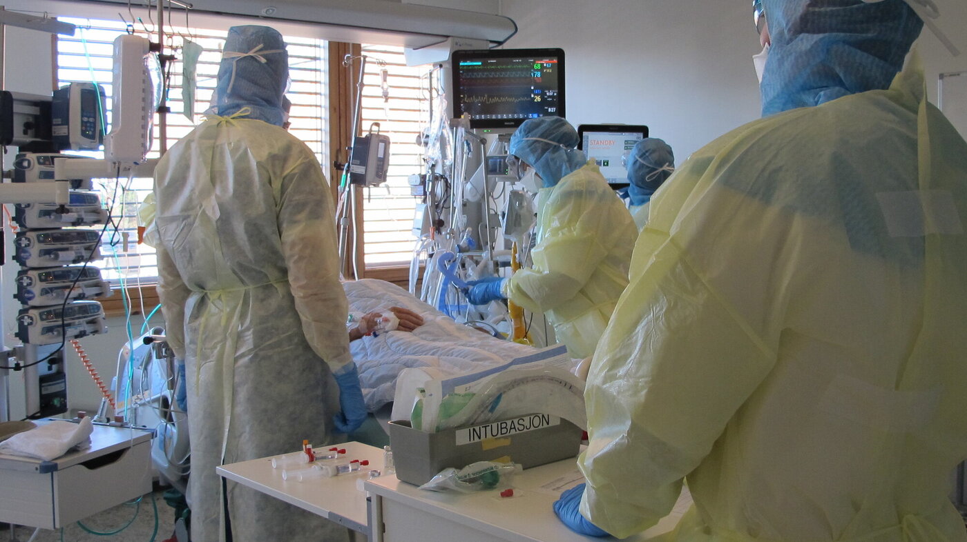 Bildet viser sykepleiere ved en pasient som er innlagt for covid-19, i en såkalt covid-kohort
