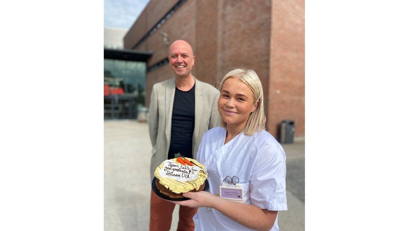 Praksis Student Lene Utzig og dekan Anders Johan W. Andersen deler ut kake til praksisplasser