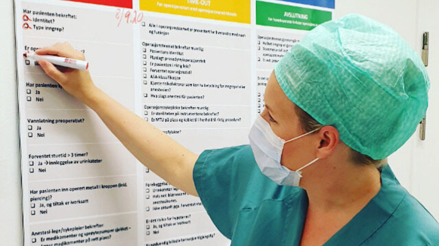Bildet viser operasjonssykepleier som krysser av på sjekkliste.