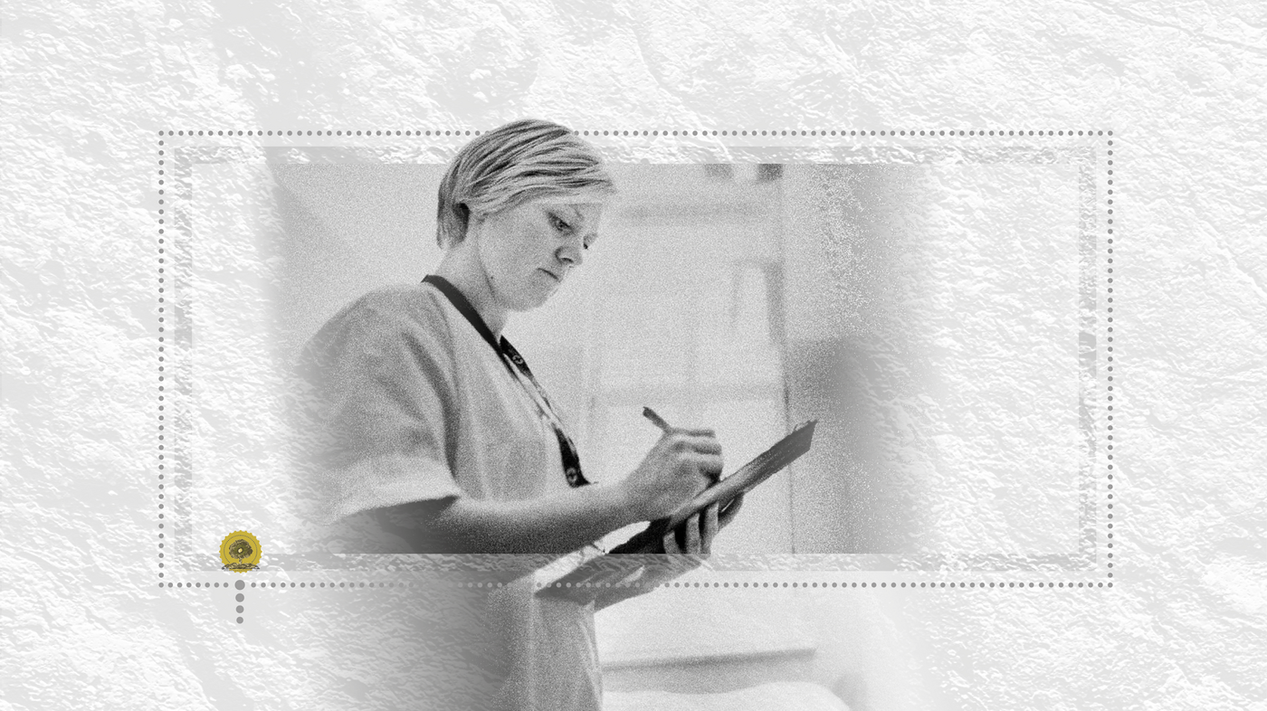 Bildet viser en sykepleier som skriver noe på et ark mens hun står oppe