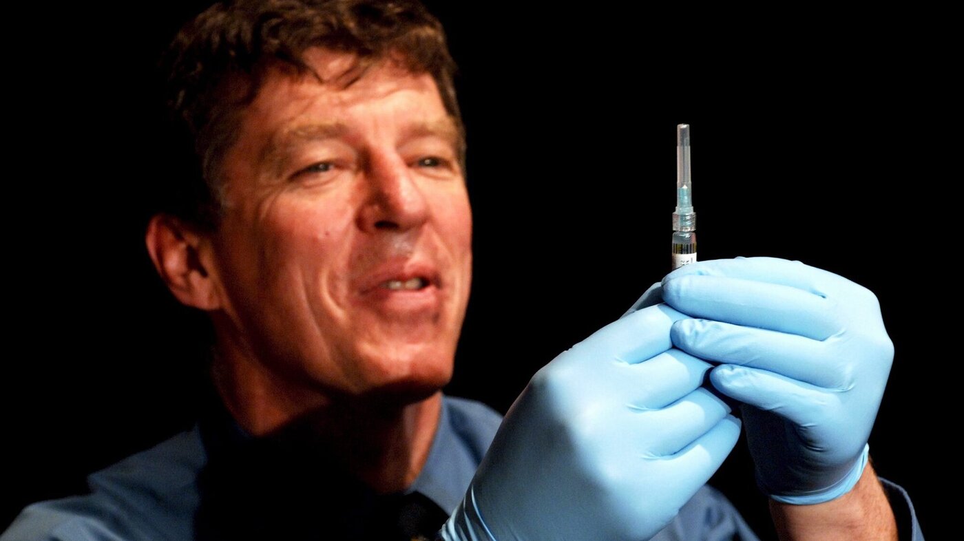 Bildet viser Ian Frazer som holder opp en vaksine.