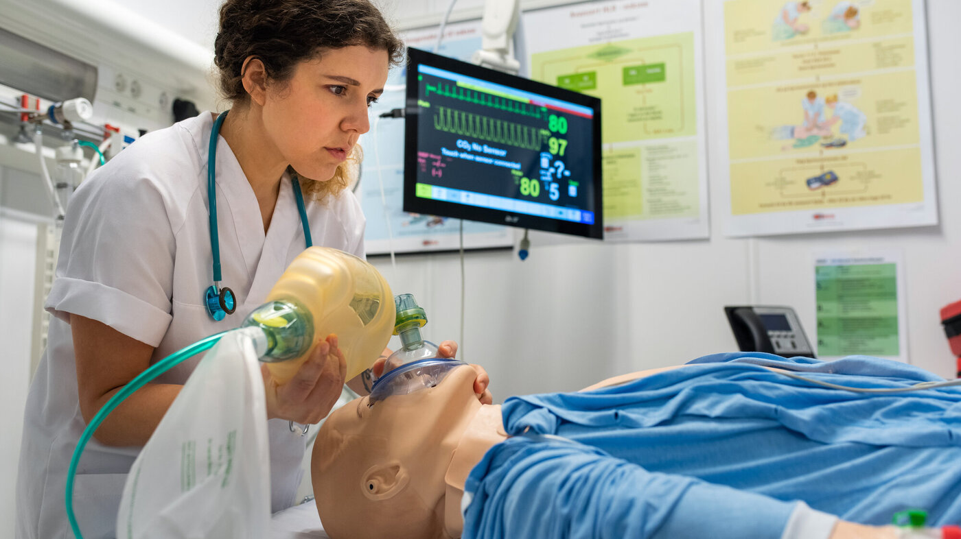Bildet viser en sykepleierstudent som øver seg på en pasientdukke