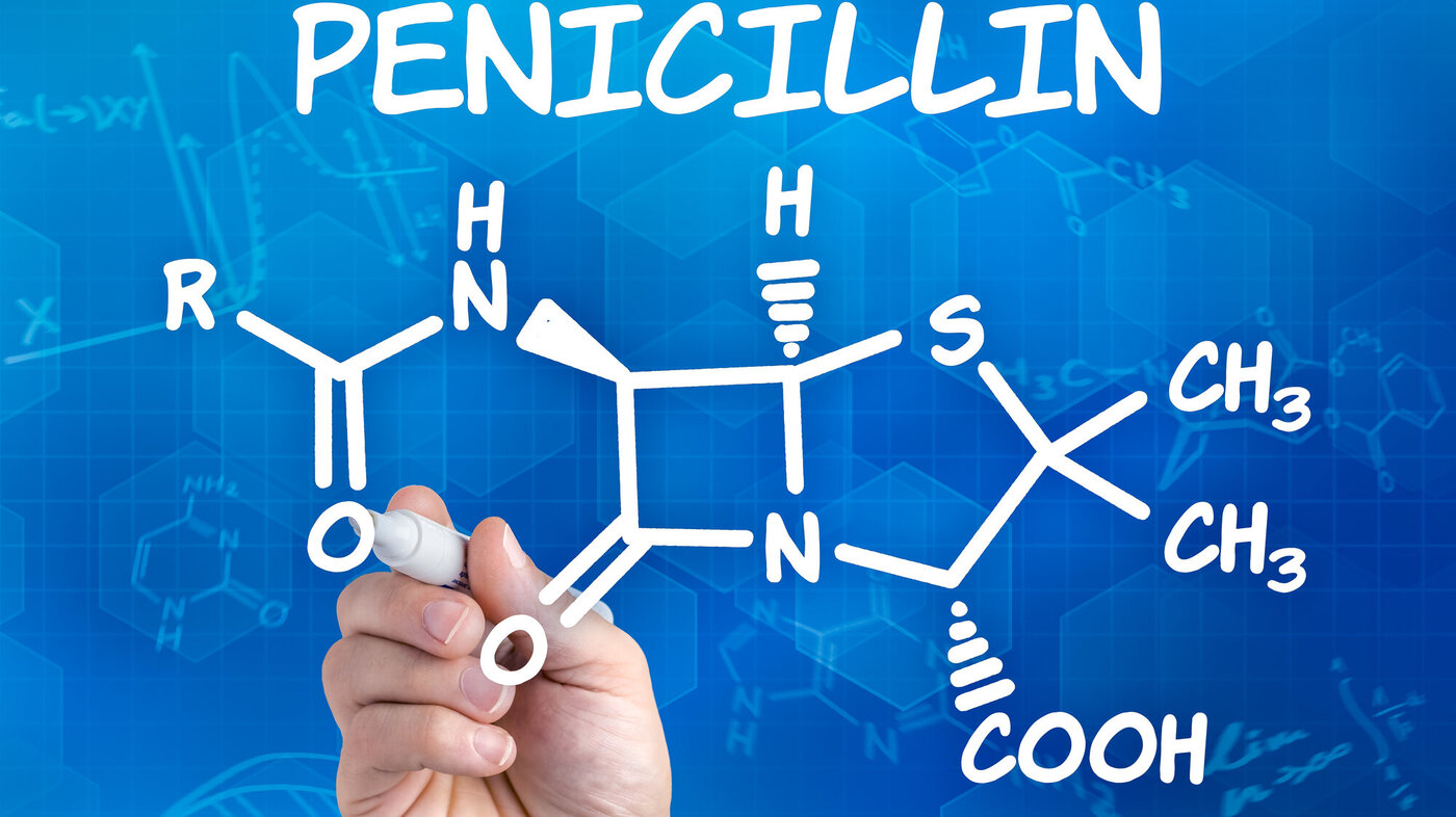 Bildet viser en hånd som skriver formelen for penicillin på en tavle.