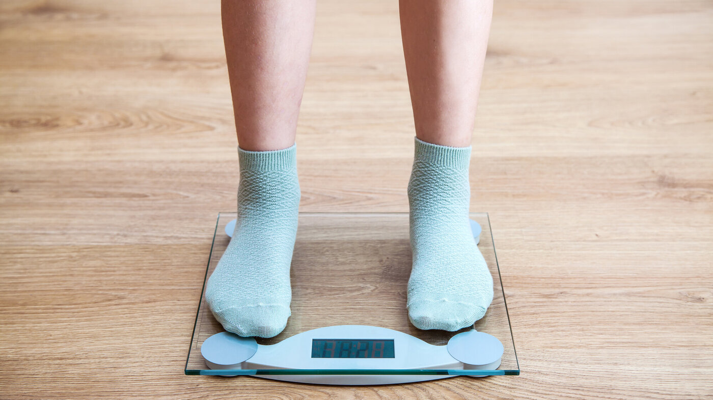 Bildet viser bena på en jente som står på en vekt