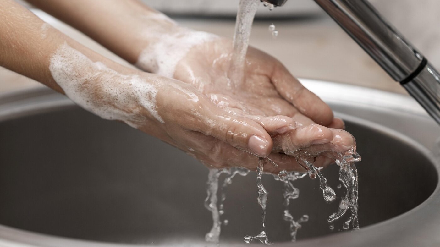 En person vasker hendene i rennende vann
