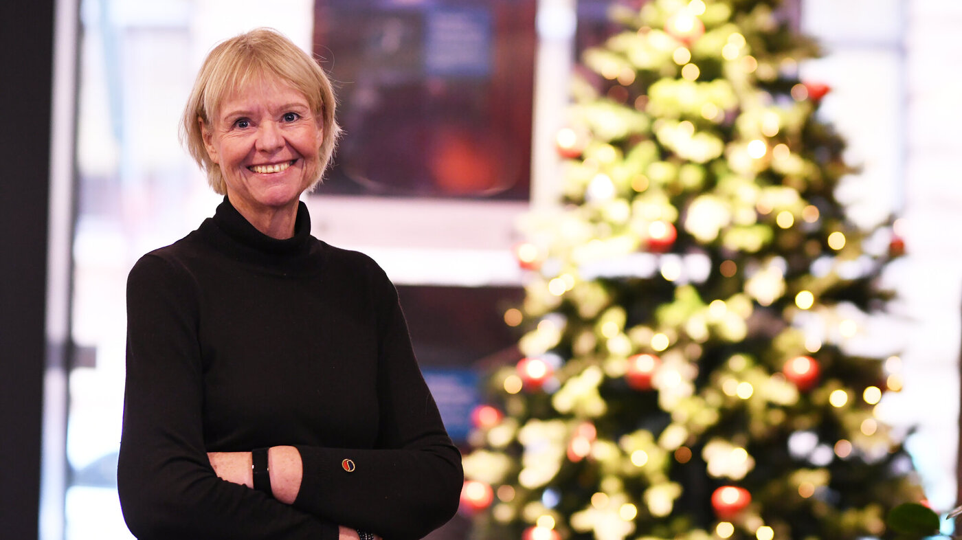 Bildet viser Anne Hafstad, redaktør i Sykepleien, smilende foran et tent juletre