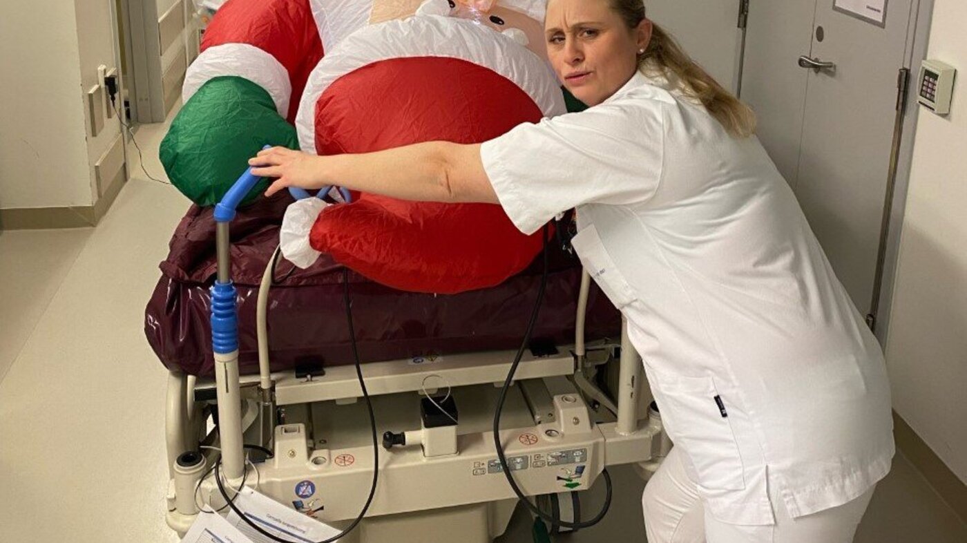 Bildet viser sykepleier Lill Heidi Anzjøn som triller plastnissen, som ligger i en seng, på intensivavdelingen på Ahus.