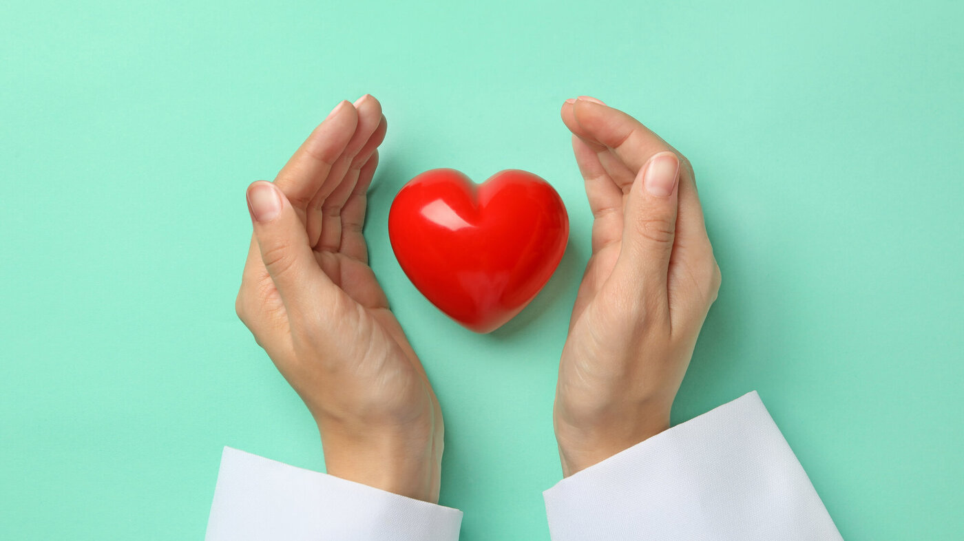 Bildet viser to hender som holder rundt et rødt hjerte