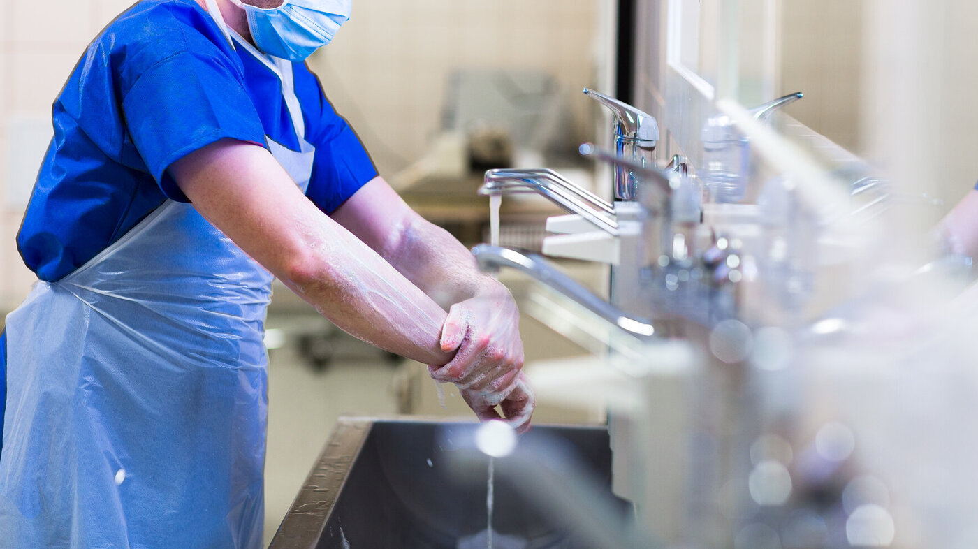 bildet viser helsearbeider som vasker hendene/armene