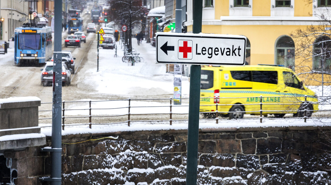 Bildet viser trafikkbildet i Oslo. Et skilt peker til Legevakta, mens en ambulanse kjører forbi