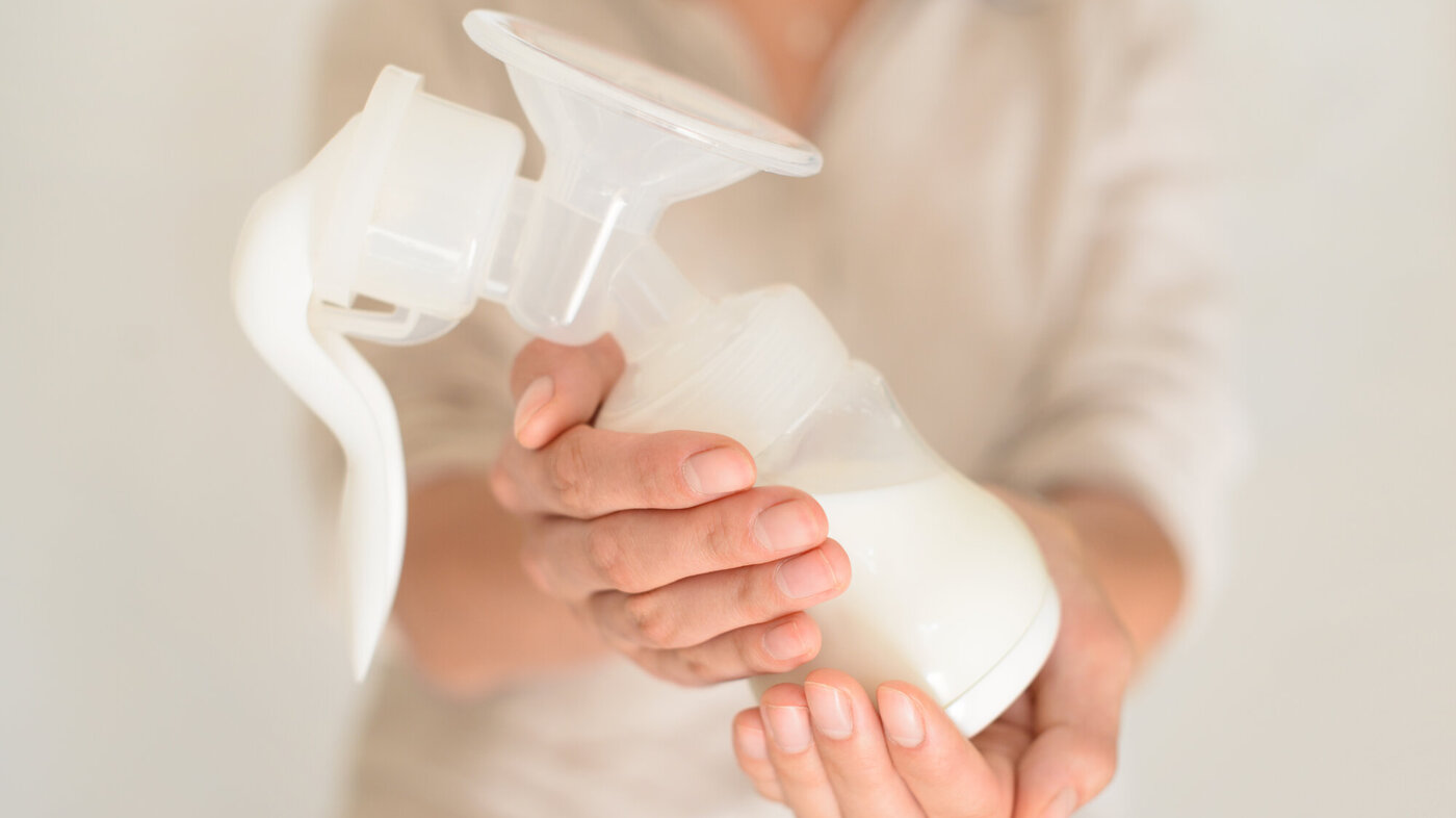 Bildet viser en kvinne som gir fra seg en flaske med morsmelk