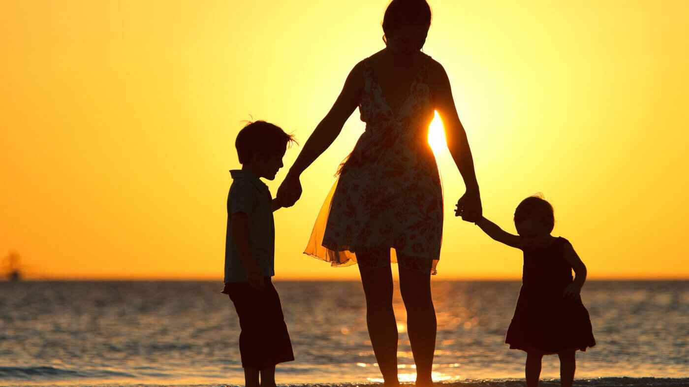Familie i solnedgang på strand