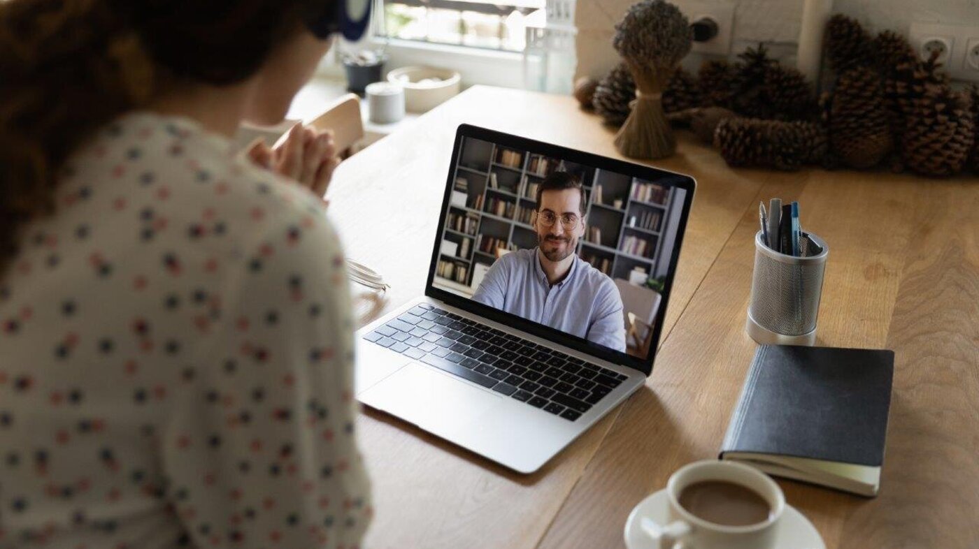 Bildet viser en kvinne som har et videomøte med en mann.