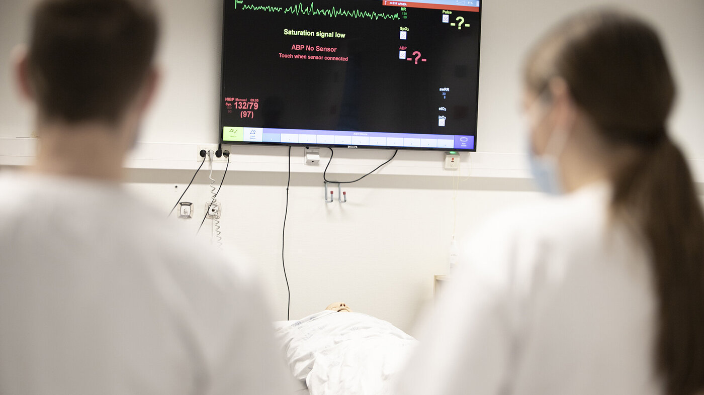 Bildet viser to sykepleiere som ser på en monitor.