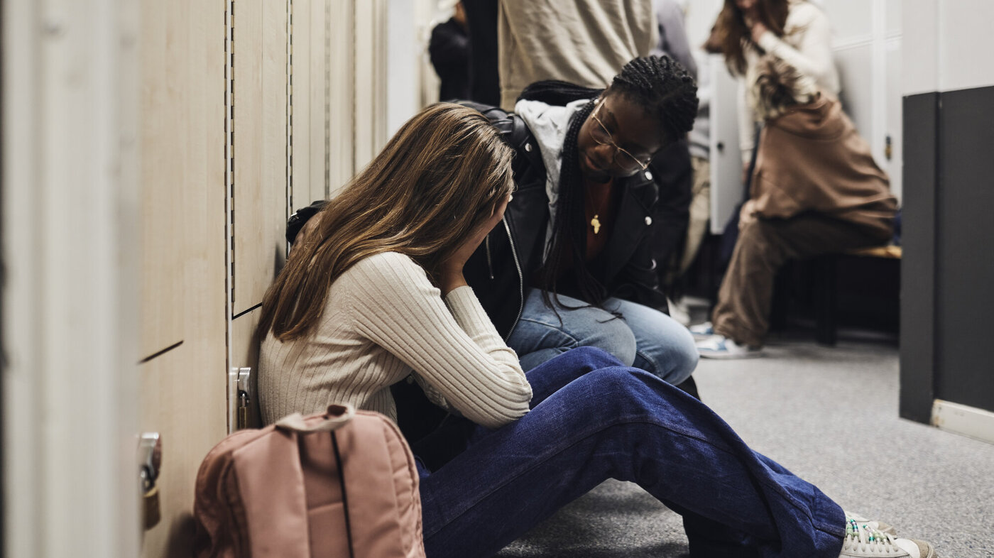 Mobbing Bildet viser en skoleansatt som trøster en gråtende jente.