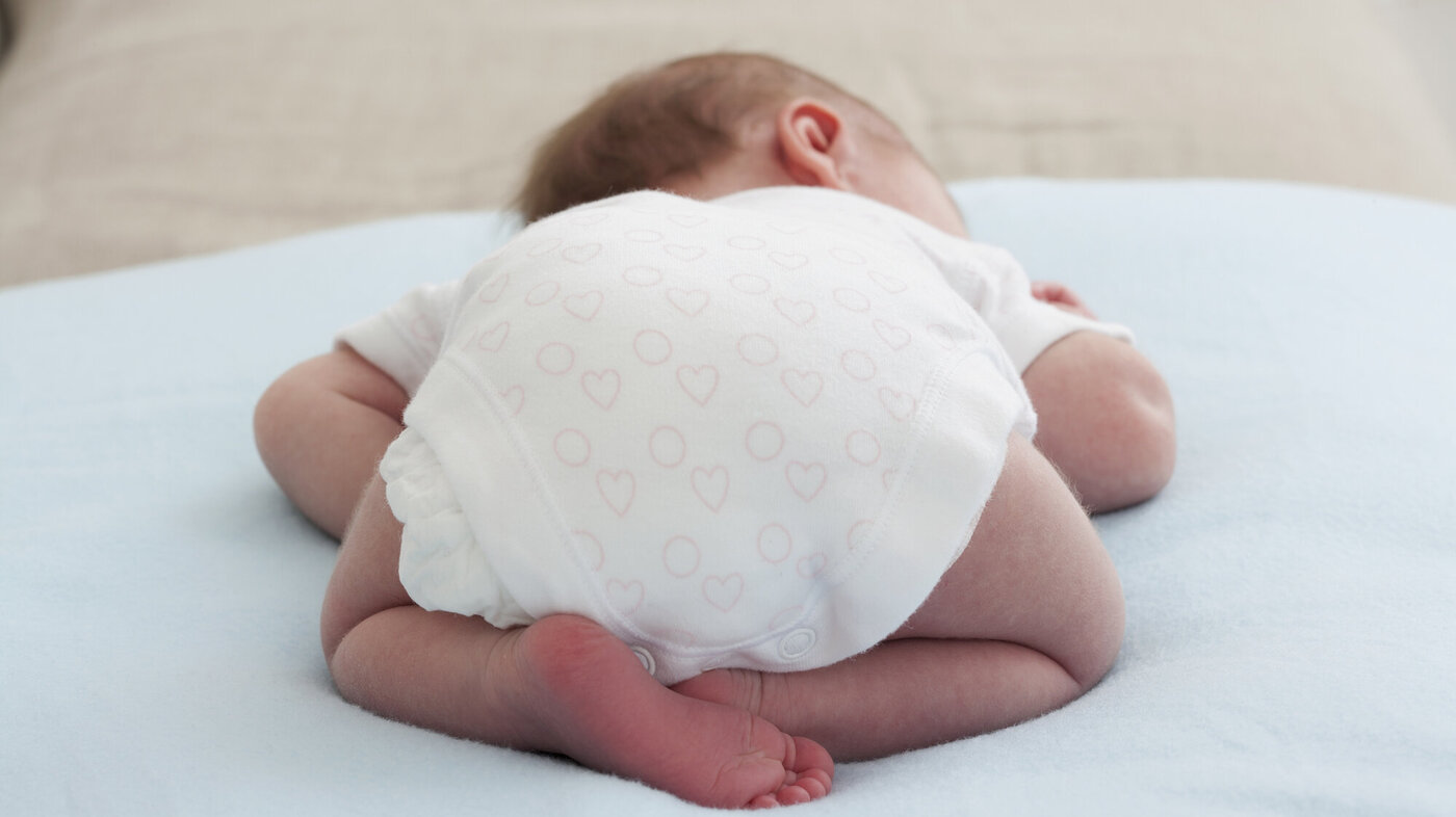 Bildet viser nyfødt baby som ligger på magen Bildet viser nyfødt baby som ligger på magen