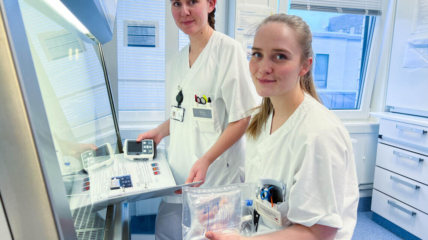Bildet viser to kvinnelige sykepleiere som holder i medisinsk utstyr