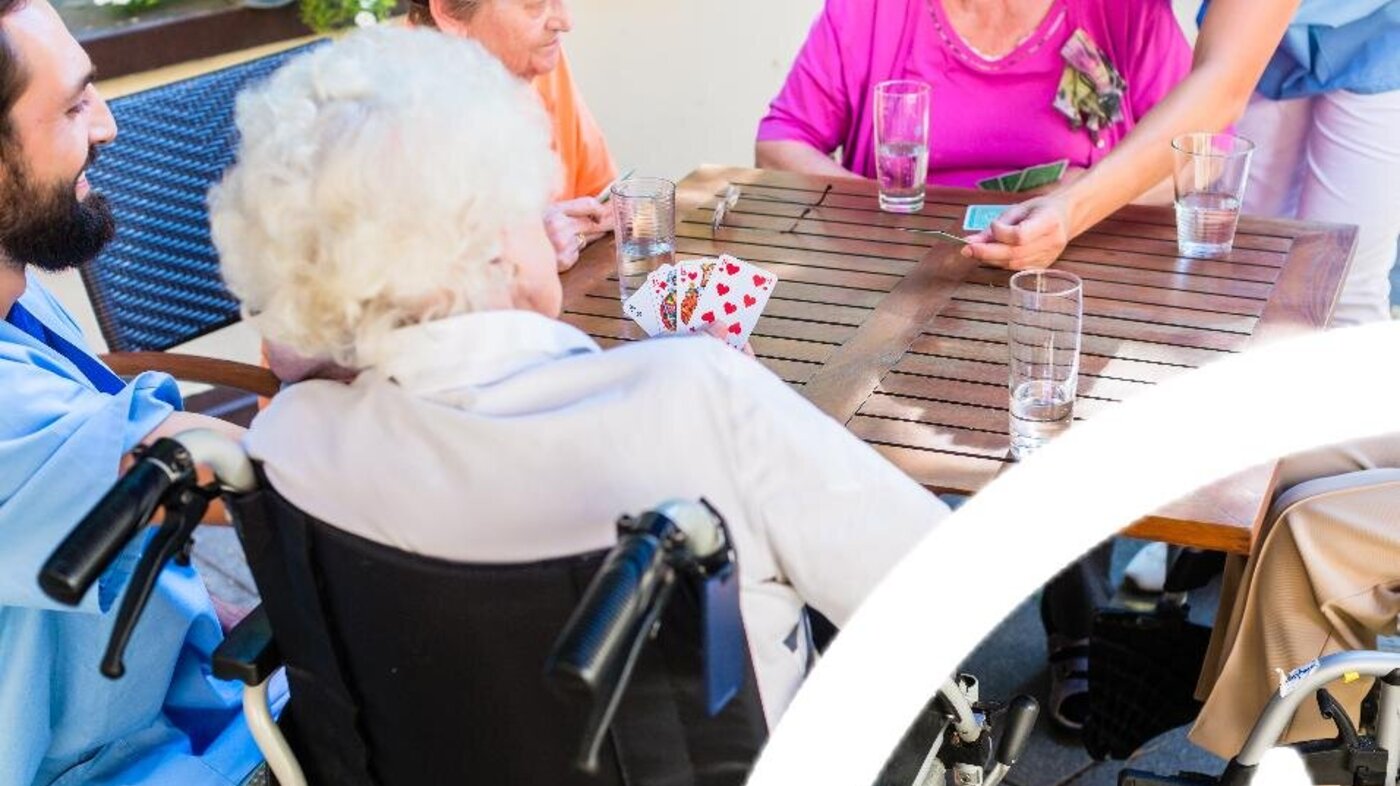Bildet viser sykehjemsbeboere som spiller kort ute