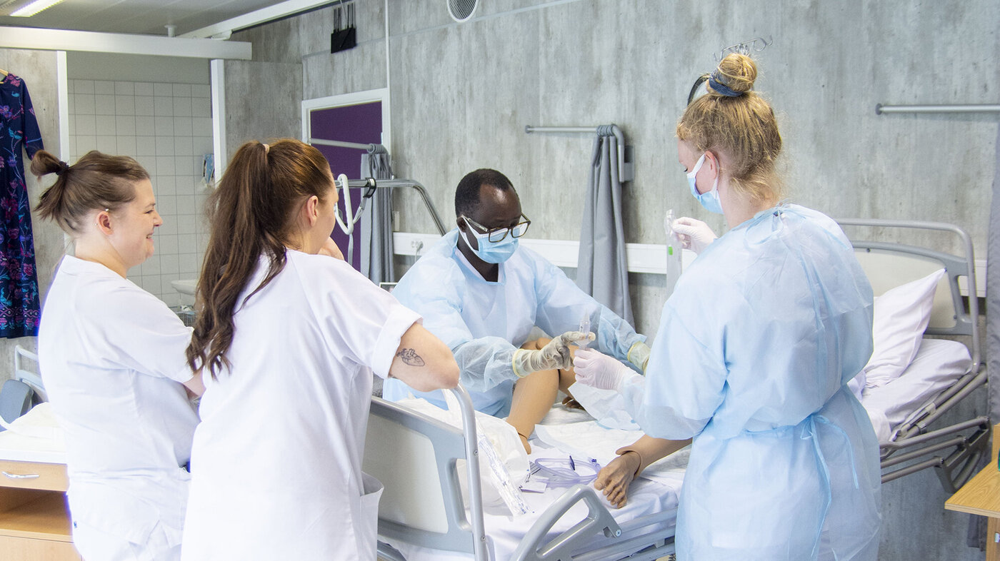 Helsesykepleierne Jean Karekezi og Kristin Olsen Holst øver på å sette inn kateter på en simuleringsdokke. De blir veiledet av slagsykepleier Adrianne Johnsen og fagutviklingssykepleier Marthe Bjørnvik.