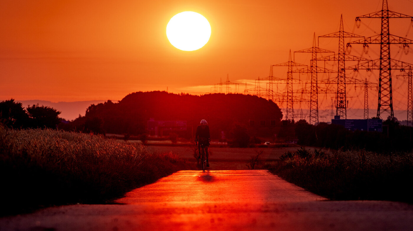 Bildet viser en mann som sykler mens solen steiker