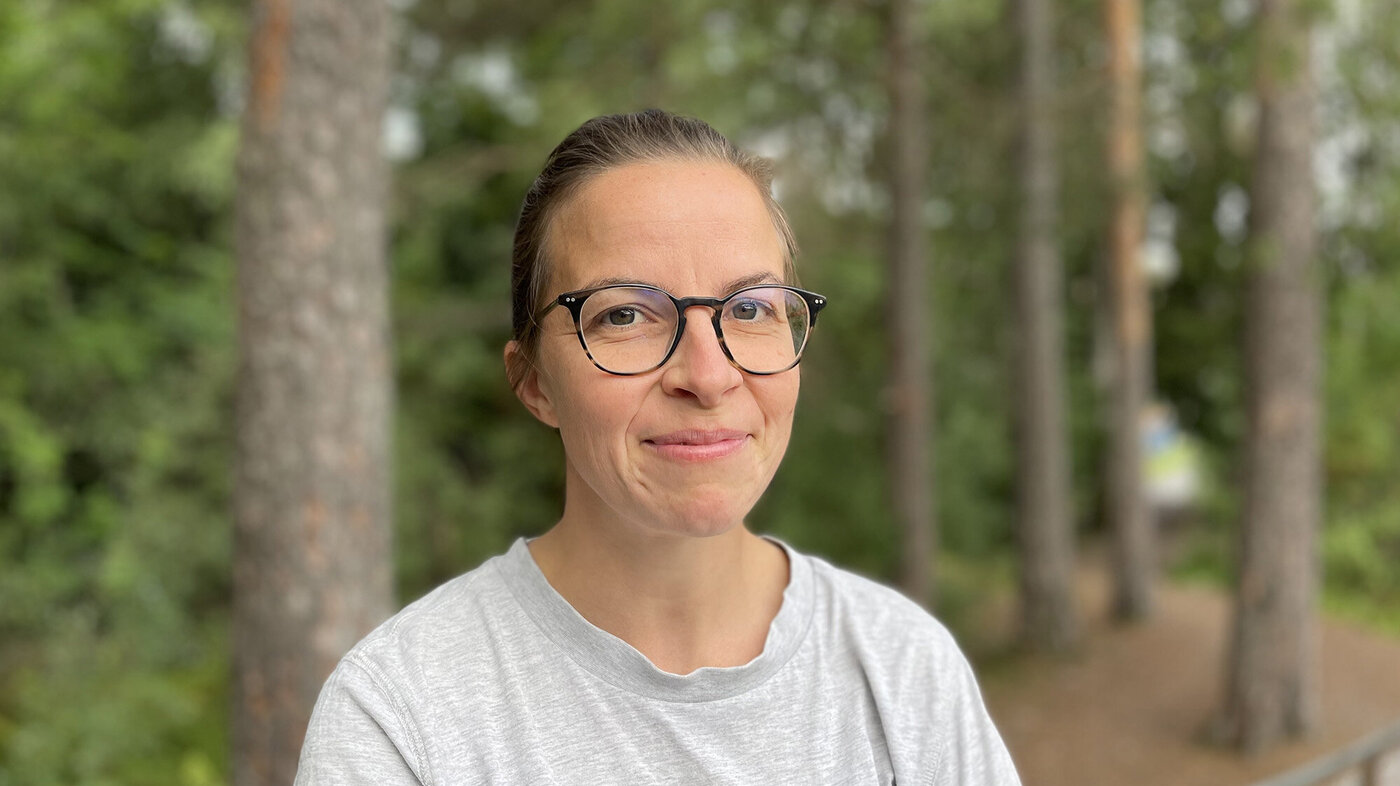 Bildet viser Karine Svelle Mellqvist omgitt av skog
