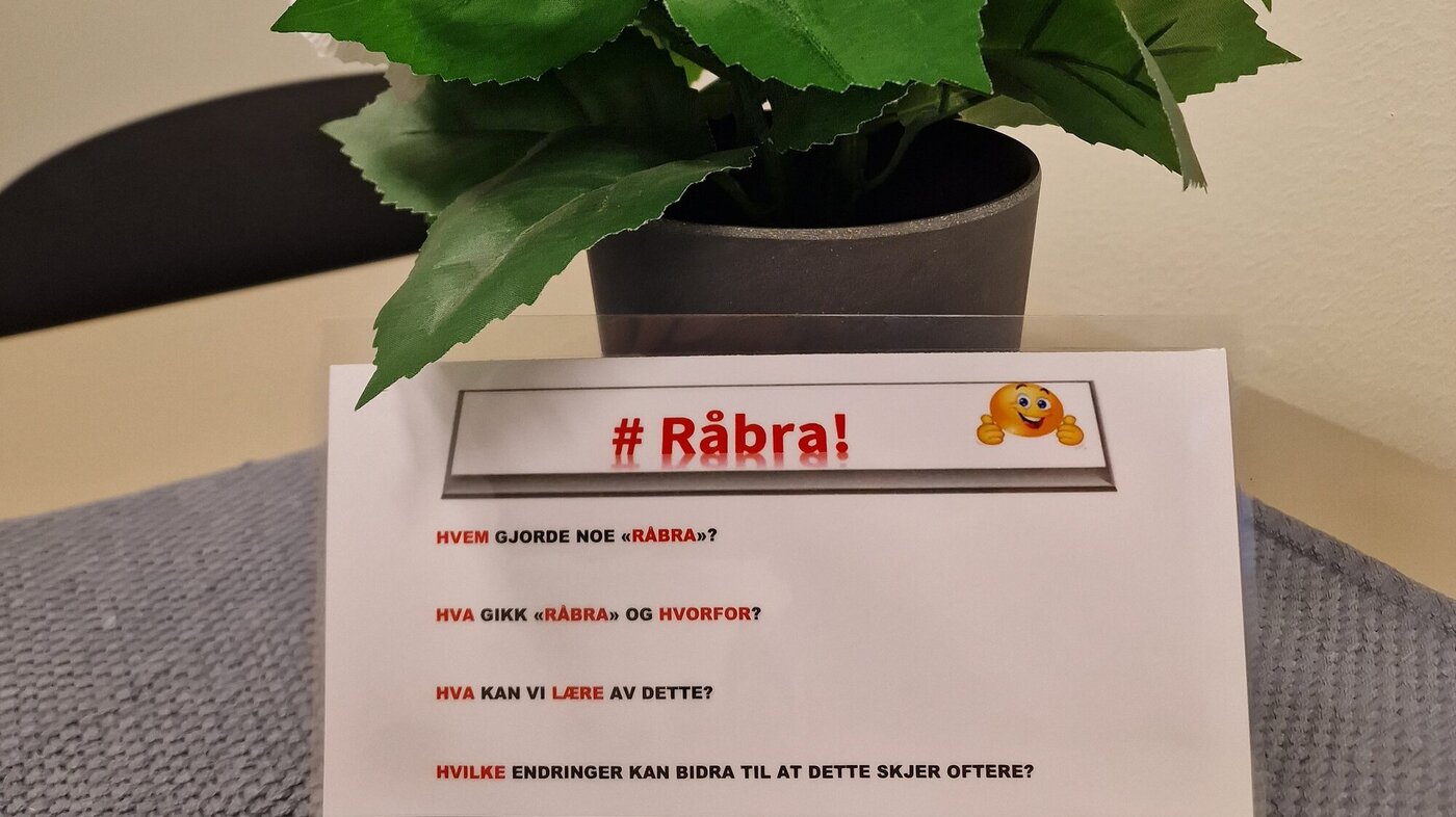 Bilde viser en blomst med en oppstilt lapp som beskriver #Råbra Bilde viser en blomst med en oppstilt lapp som beskriver #Råbra