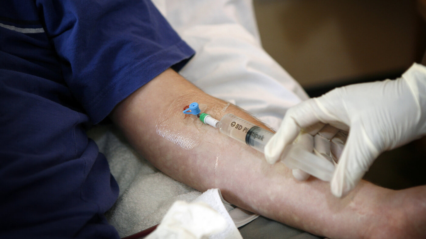 Bildet viser en sykepleier som gir intravenøs antibiotika til en pasient.