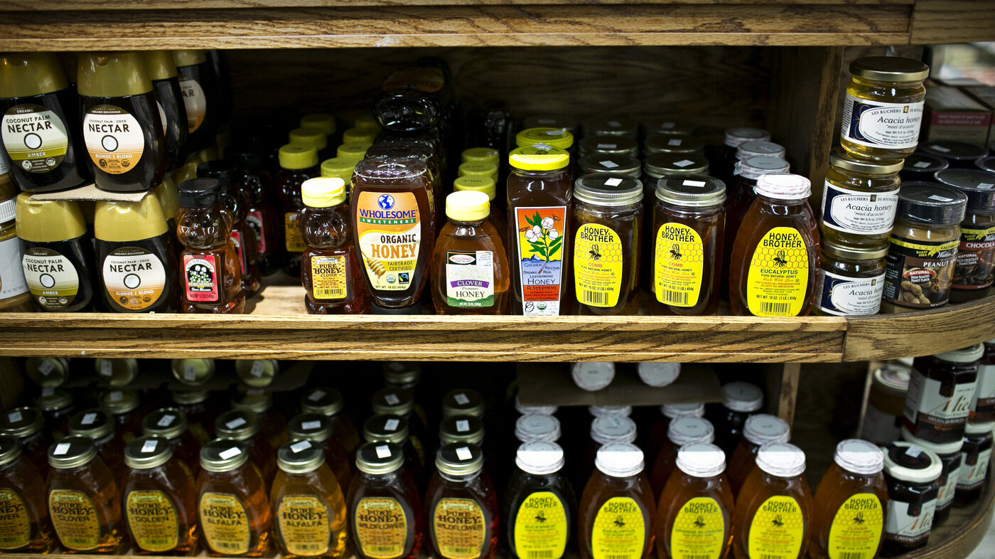 Bildet viser en butikkhylle full av honning